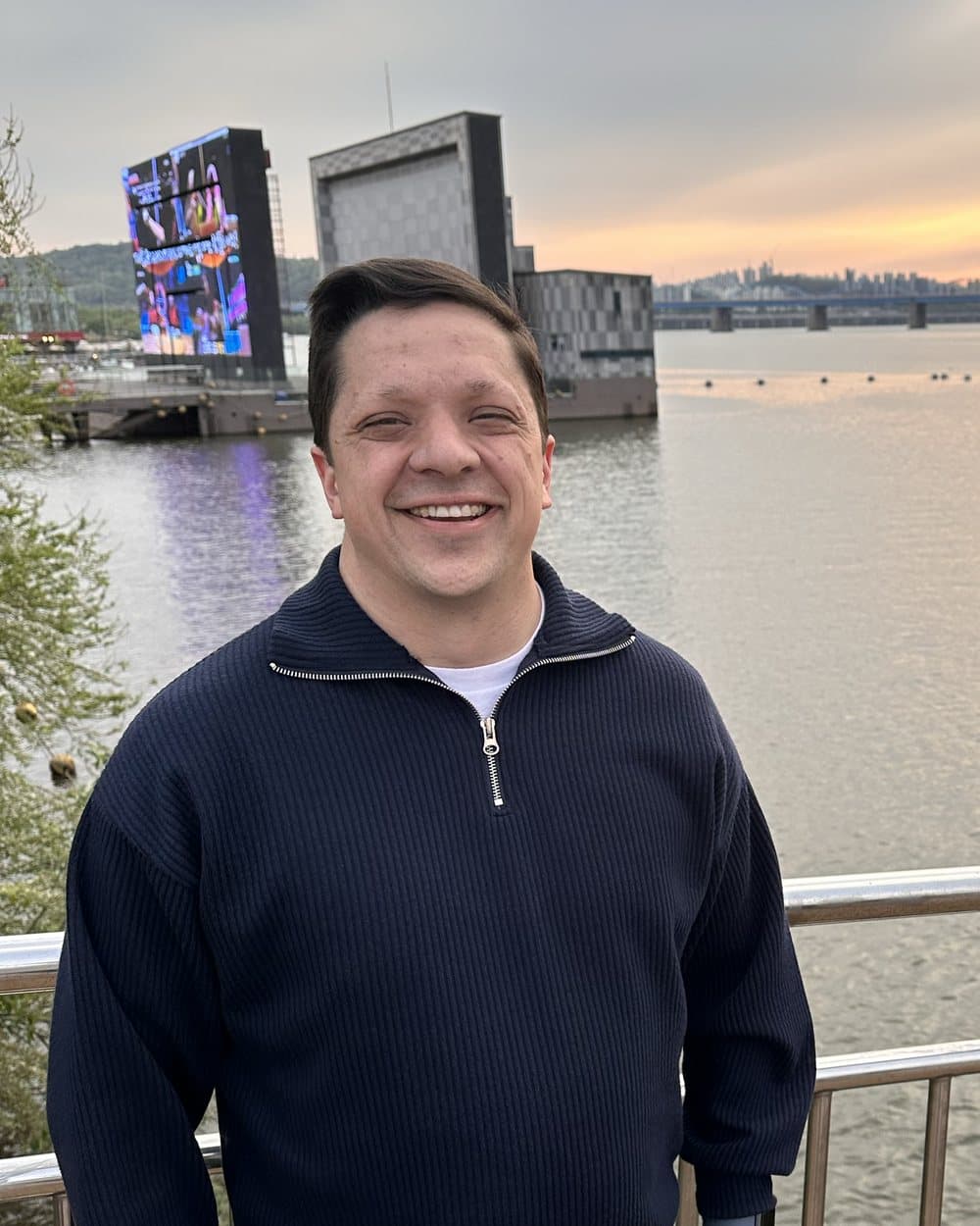 James Briggs beside the river at sunset